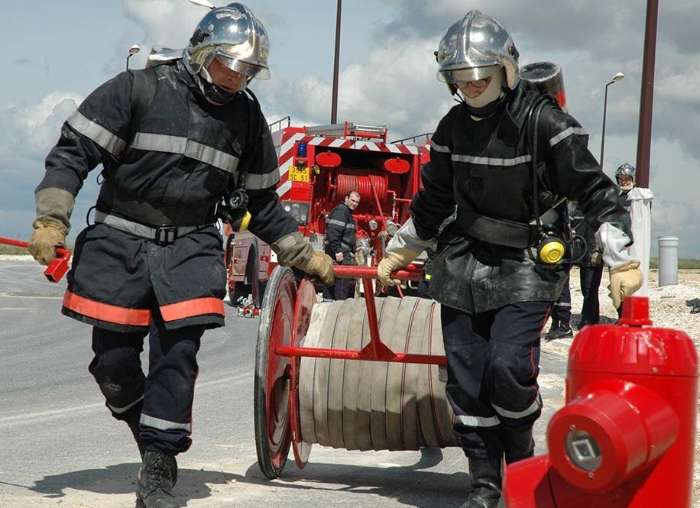 Sapeurs-pompiers professionnels déroulant un dévidoir lors d'une manœuvre